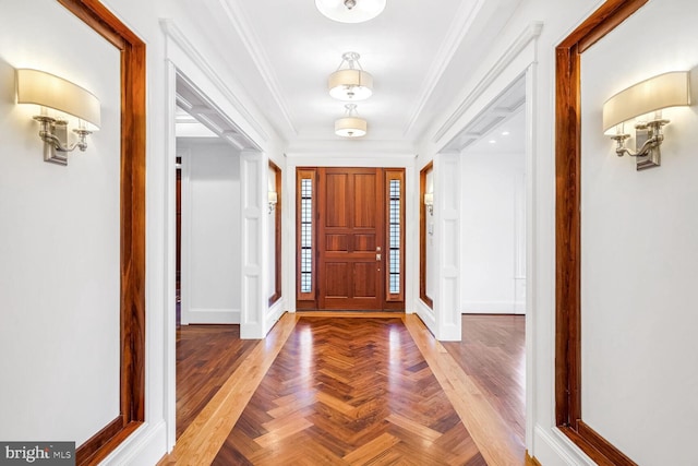 entrance foyer with ornamental molding and parquet flooring