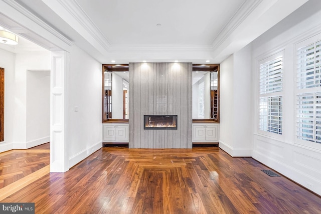 unfurnished living room with crown molding, a large fireplace, and a tray ceiling