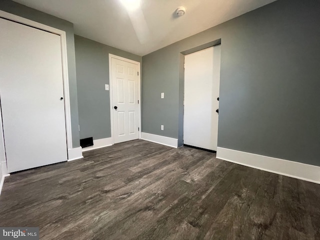 unfurnished bedroom featuring dark wood-type flooring