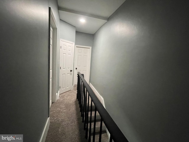 hallway with dark colored carpet