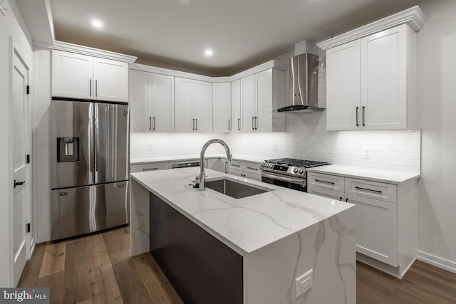 kitchen with sink, wall chimney exhaust hood, appliances with stainless steel finishes, dark hardwood / wood-style flooring, and white cabinetry