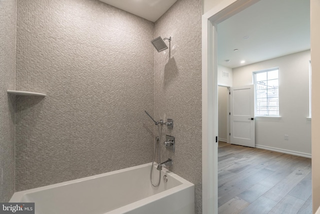 bathroom featuring hardwood / wood-style flooring and tiled shower / bath combo