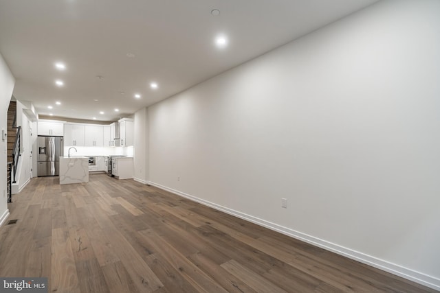 unfurnished living room with hardwood / wood-style floors and sink