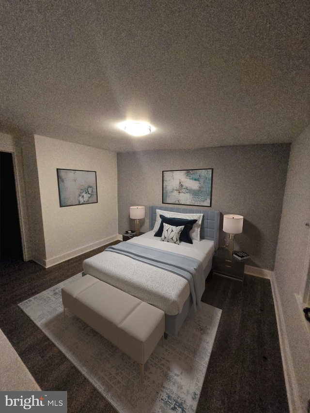 bedroom with dark wood-type flooring and a textured ceiling