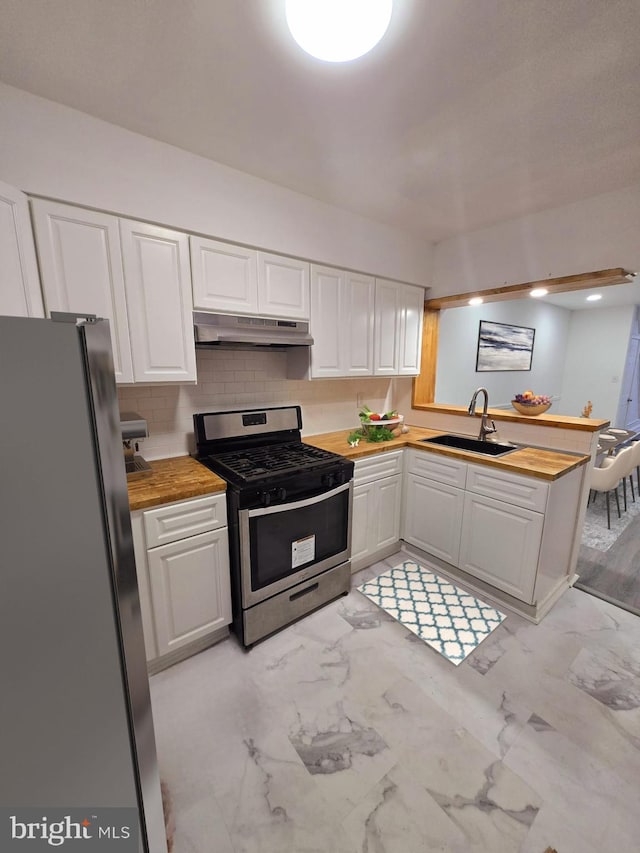 kitchen featuring butcher block counters, sink, stainless steel appliances, kitchen peninsula, and white cabinets