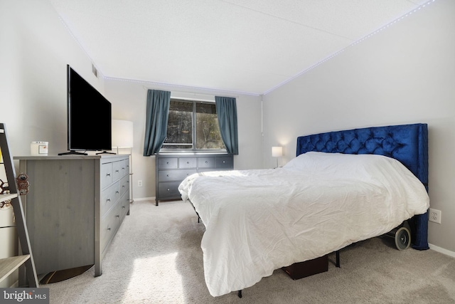 bedroom with ornamental molding and light carpet