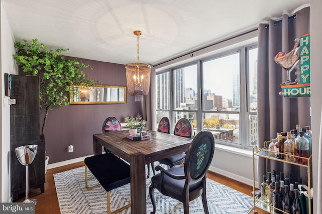 dining room featuring hardwood / wood-style floors, a healthy amount of sunlight, and a chandelier