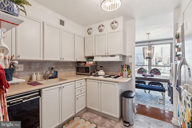 kitchen with white cabinets, black dishwasher, light hardwood / wood-style floors, and an inviting chandelier