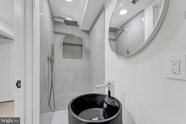 bathroom with sink and tiled shower