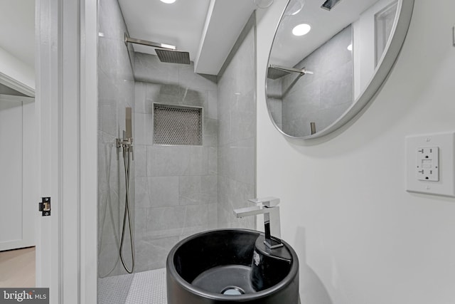 bathroom with a tile shower and sink