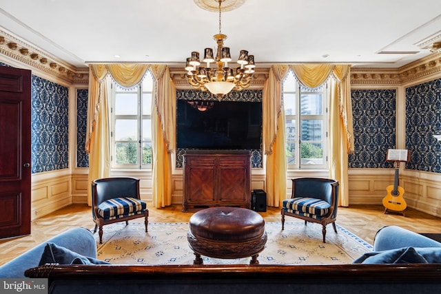 sitting room with a chandelier, ornamental molding, light parquet floors, and a healthy amount of sunlight