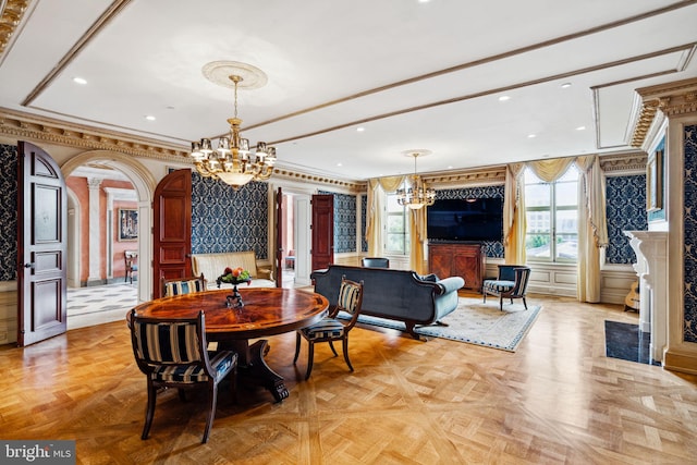 dining room with ornate columns, an inviting chandelier, light parquet floors, and ornamental molding