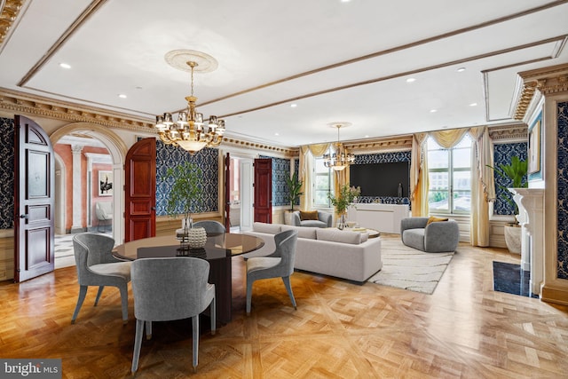 dining area featuring a chandelier, light parquet floors, crown molding, and ornate columns