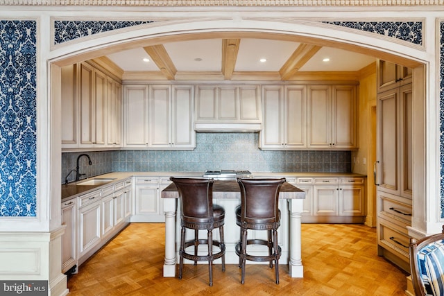 kitchen featuring beam ceiling, tasteful backsplash, sink, and light parquet flooring