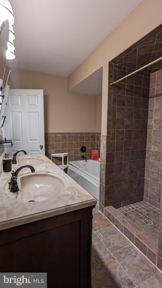 bathroom featuring vanity and independent shower and bath