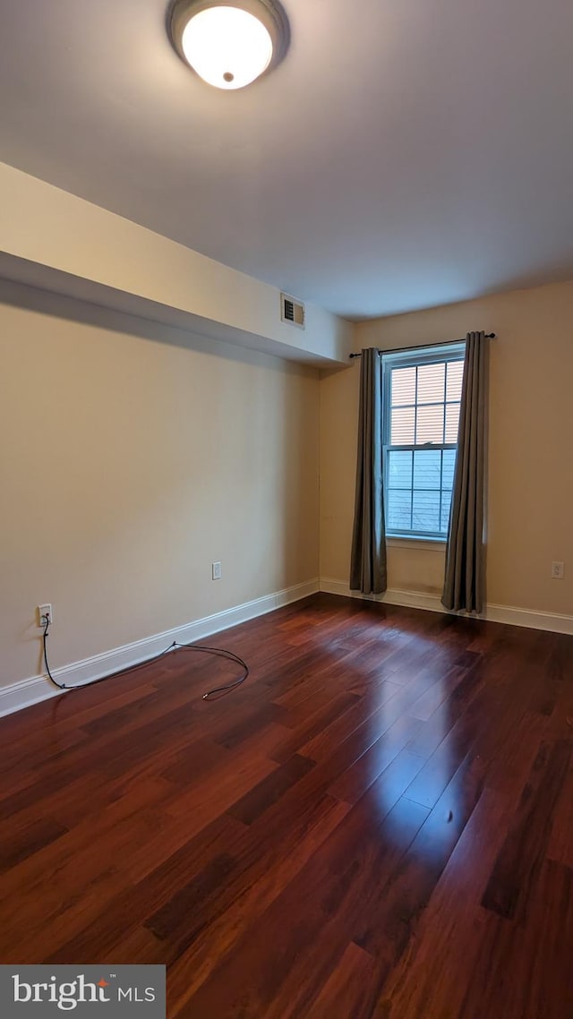 empty room with dark hardwood / wood-style floors