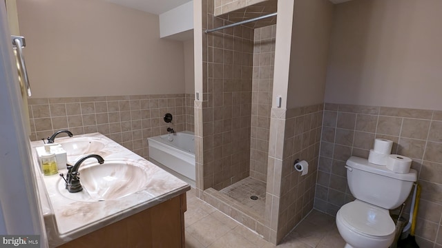 full bathroom featuring shower with separate bathtub, toilet, and tile walls