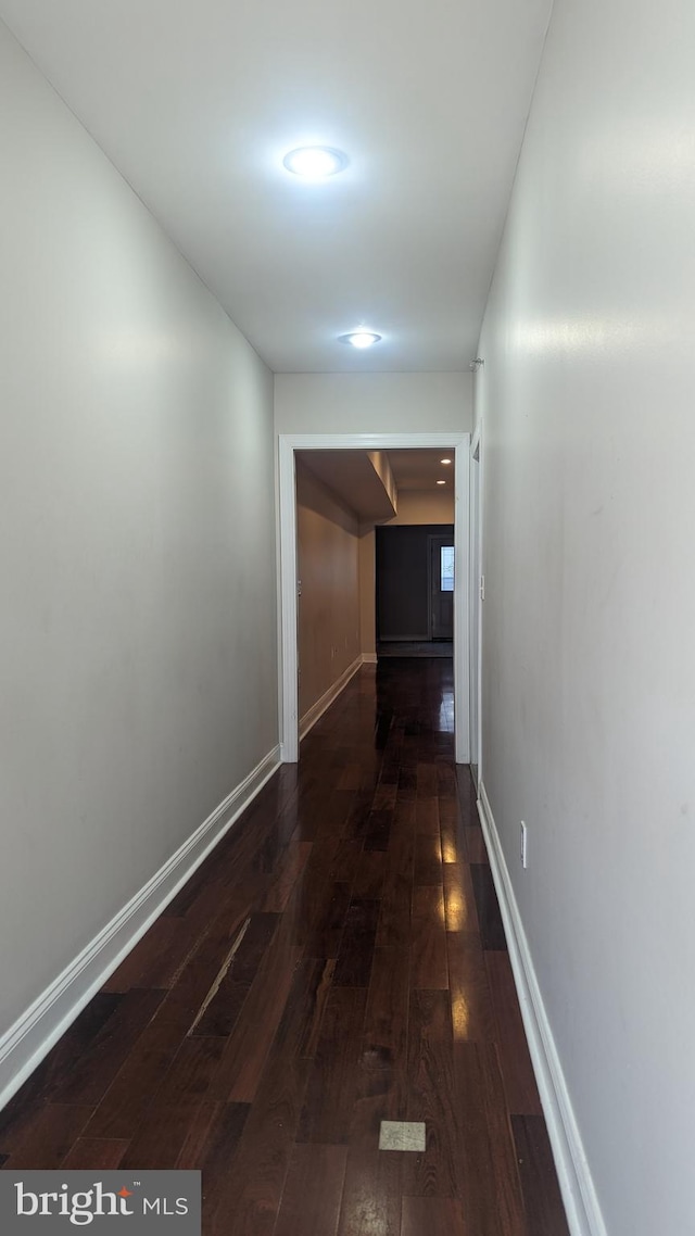 hallway with dark hardwood / wood-style flooring