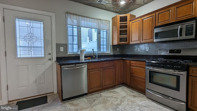 kitchen with dark stone countertops, sink, and appliances with stainless steel finishes