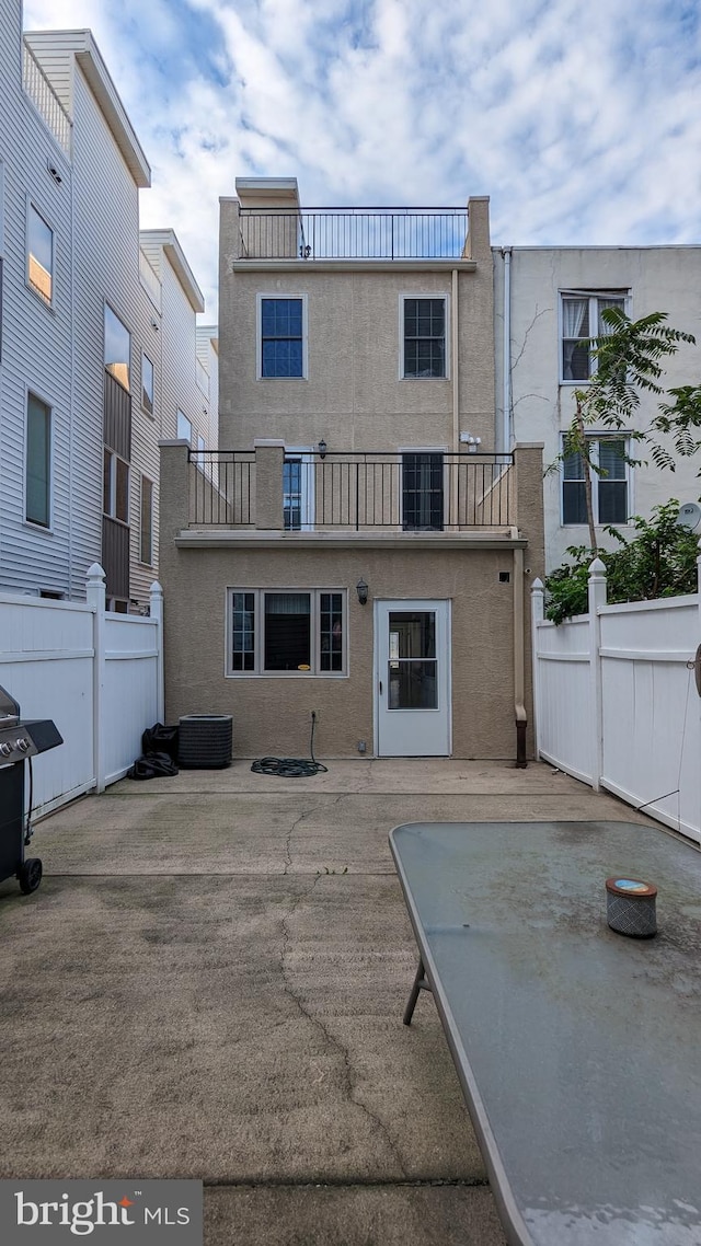 back of property featuring a patio area and a balcony