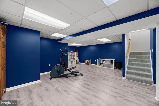 exercise area with light hardwood / wood-style flooring and a drop ceiling