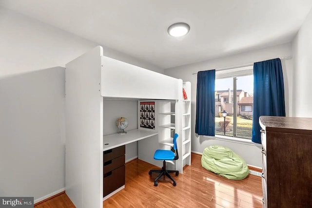 bedroom with light wood-type flooring and multiple windows