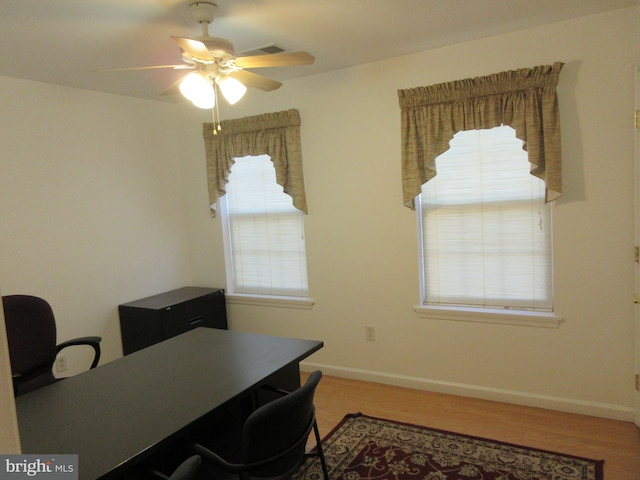 home office with hardwood / wood-style floors and ceiling fan