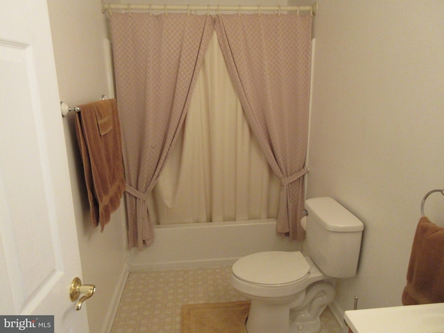 bathroom featuring shower / tub combo and toilet