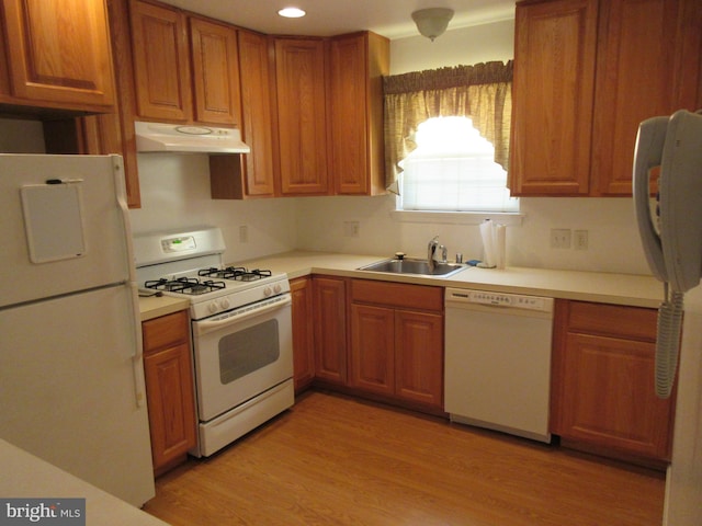 kitchen with sink, white appliances, and light wood-type flooring