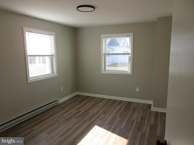 spare room featuring a baseboard radiator and dark wood-type flooring