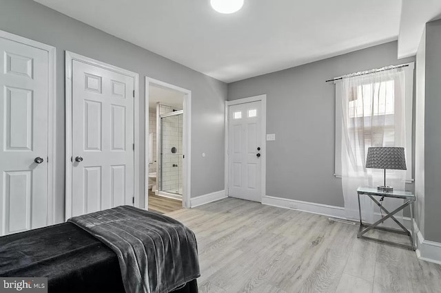 bedroom featuring light hardwood / wood-style flooring and ensuite bath