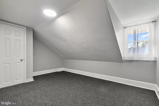 bonus room featuring dark colored carpet and vaulted ceiling