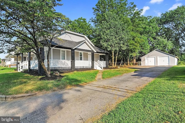 view of front facade with an outbuilding, a front lawn, covered porch, and a garage