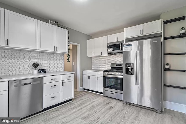 kitchen with appliances with stainless steel finishes, backsplash, and white cabinetry