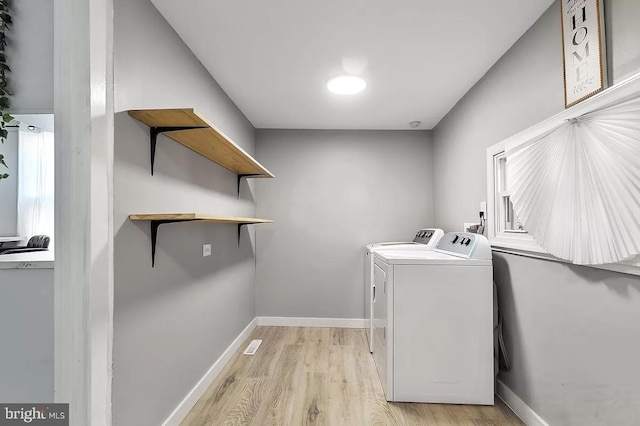 washroom featuring washer and clothes dryer and light wood-type flooring