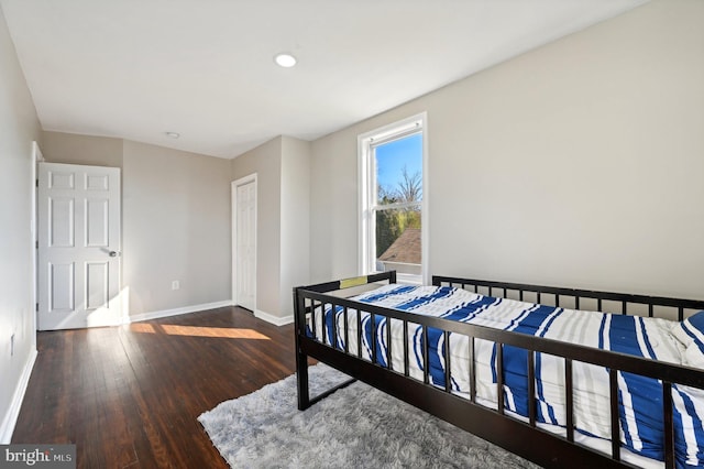 bedroom with dark hardwood / wood-style floors