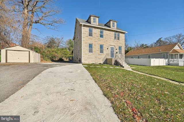 view of front of home with a front lawn, an outdoor structure, and a garage