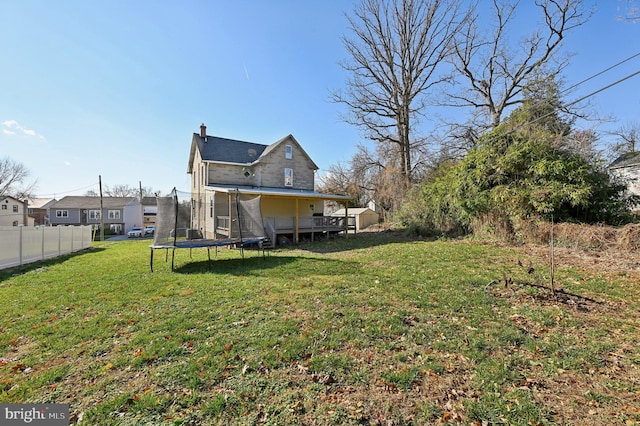 view of yard with a wooden deck and a trampoline