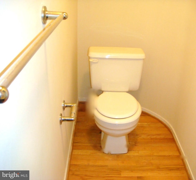 bathroom with hardwood / wood-style flooring and toilet