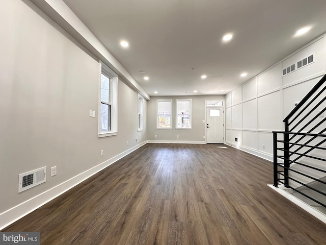 unfurnished living room with dark wood-type flooring