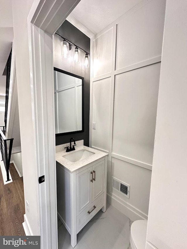 bathroom featuring hardwood / wood-style flooring, vanity, and toilet