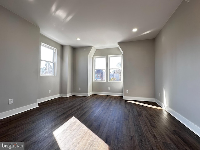 unfurnished room featuring a healthy amount of sunlight and dark wood-type flooring