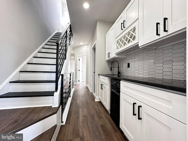 kitchen with white cabinets, decorative backsplash, dark wood-type flooring, and sink