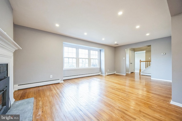 unfurnished living room with a baseboard radiator and light hardwood / wood-style floors