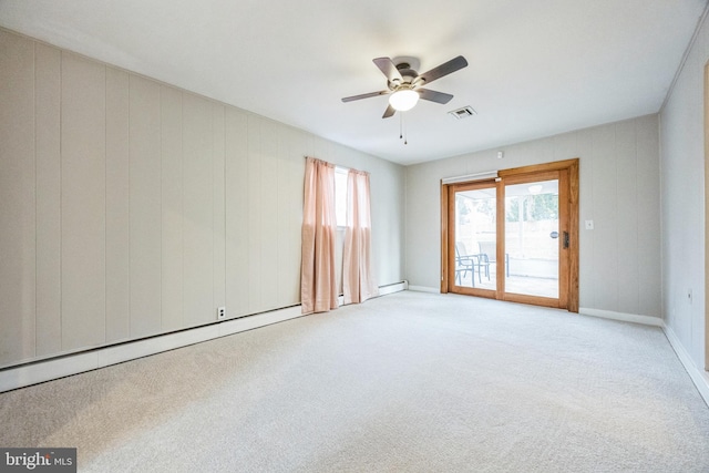 carpeted spare room featuring ceiling fan and a baseboard heating unit