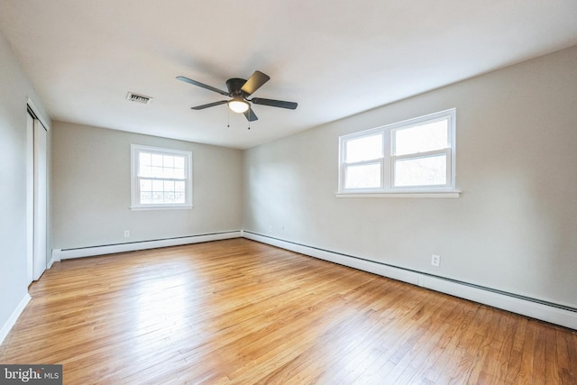 empty room featuring ceiling fan, light hardwood / wood-style floors, and baseboard heating