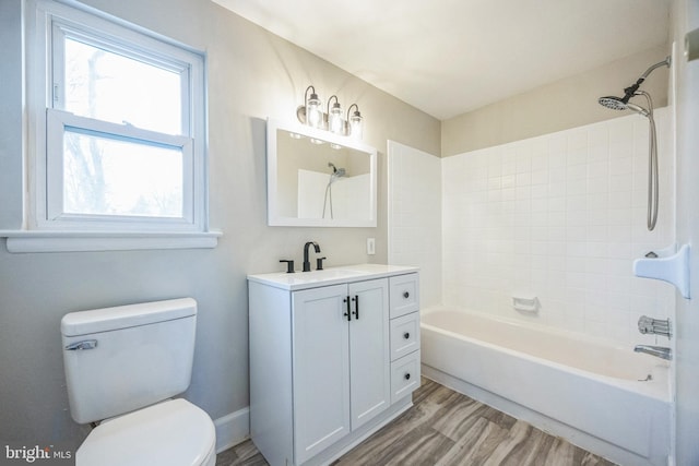 full bathroom featuring hardwood / wood-style floors, vanity, toilet, and tiled shower / bath