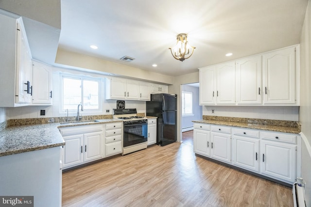 kitchen with white cabinets, white gas range oven, light hardwood / wood-style floors, and sink