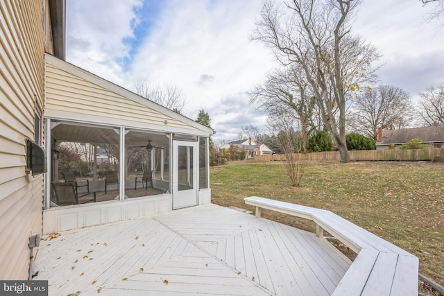 deck with a sunroom and a yard