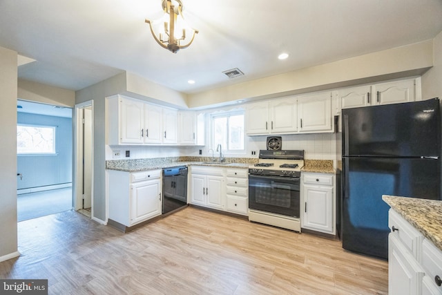 kitchen with white cabinetry, black appliances, and light hardwood / wood-style floors